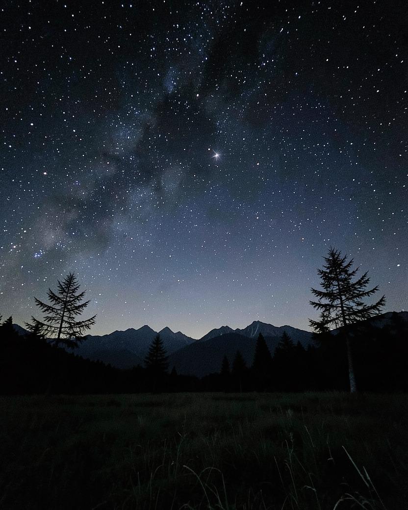 高原の夜。山並みの上に広がる星空